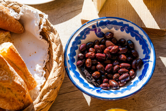 Bowl of dates lying next to basket with bread