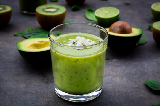 Green smoothie with avocado, spinach, kiwi and lime, coconut flakes and black sesame