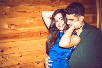 Romantic young couple dancing against wooden wall in party