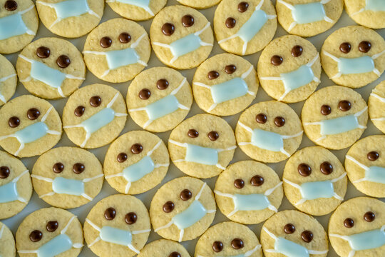 Rows of Christmas cookies with faces wearing protective face masks