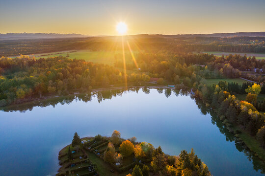 Germany, Bavaria, Upper Bavaria, Toelzer Land, Konigsdorf, Aerial view of Baggersee and forests at sunset