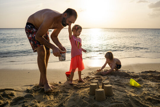 Father playing with his children on the beach at sunset, Willemstad, Curacao