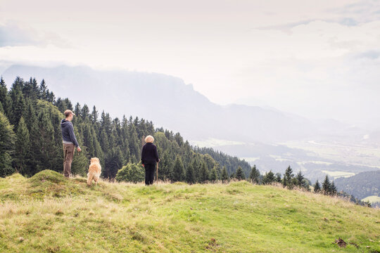 Austria, Tyrol, Kaiser mountains, mother and adult son with dog on a hiking trip in the mountains