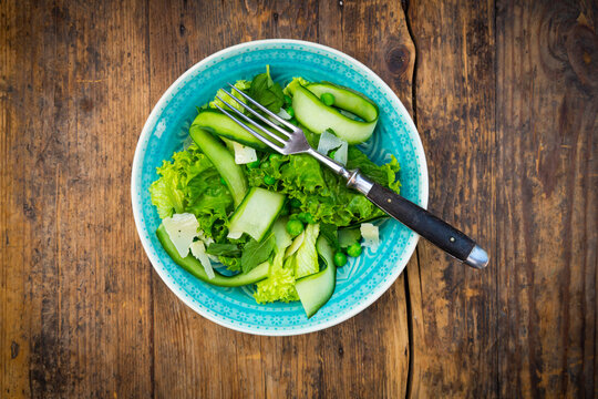 Plate of salad with green peas, mint, cucumber, Parmesan cheese and Lollo Bionda lettuce
