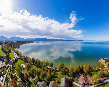 Germany, Bavaria, Chieming, Clouds over Chiemsee lake and lakeshore houses on sunny autumn day