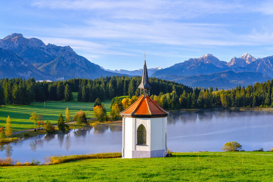 Germany, Bavaria, Halblech, Chapel against Hegratsrieder See lake in Tannheim Mountains