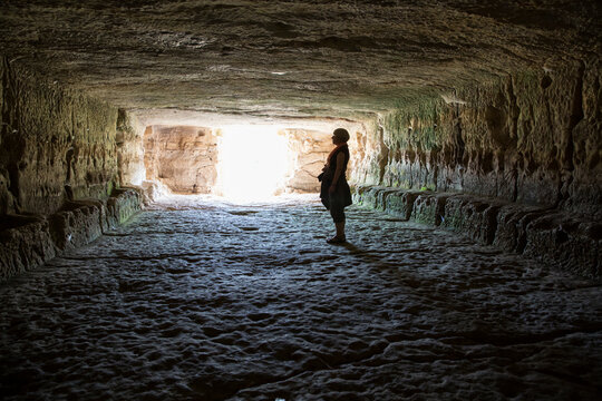 Italy, Sicily, Province of Ragusa, Parco Archeologico Forza, Cava d`Ispica, Il ginnasio, woman looking on wall