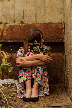 Sad lonely woman sitting in container