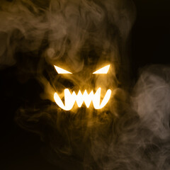 Horror face glows in darkness through thick smoke clouds creating quaint patterns