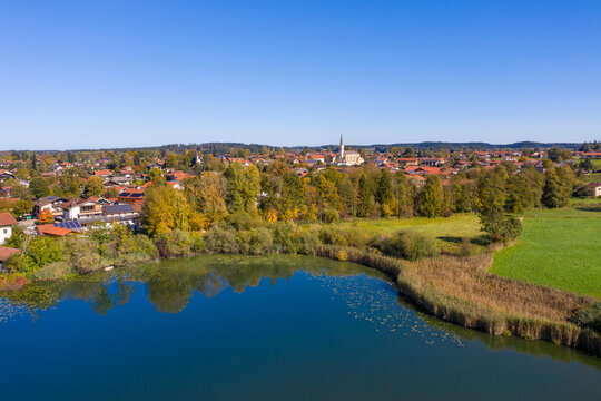 Germany, Bavaria, Chieming, Clear sky over town on shore of Pfeffersee lake in autumn