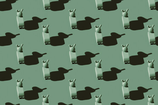 Pattern of small green donkey figurines against pastel green background