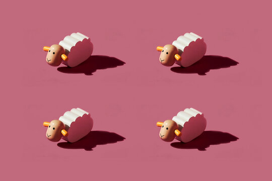 Pattern of small white sheep figurines against red background