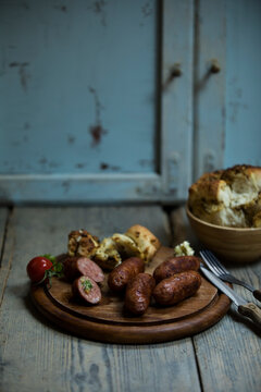 Fried salsiccia on cutting board with pickled bread