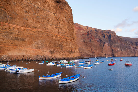 Spain, La Gomera Valle Gran Rey, Boats moored in front of coastal cliff