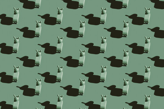 Pattern of small green donkey figurines against pastel green background