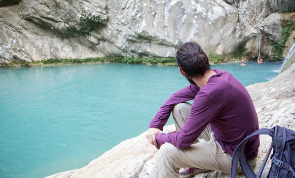 Greece, Messenia, man watching the Polylimnio waterfalls near Kazarma
