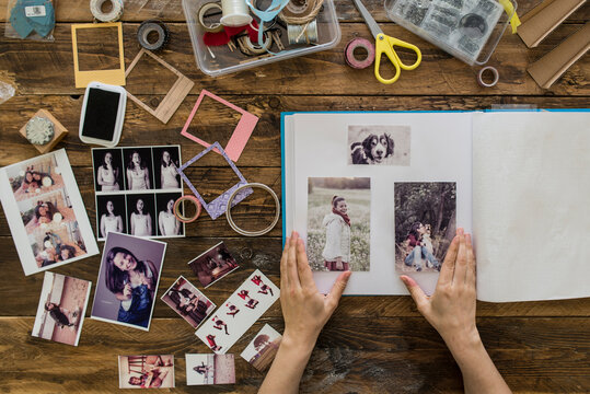 Top view of woman's hands designing photo album