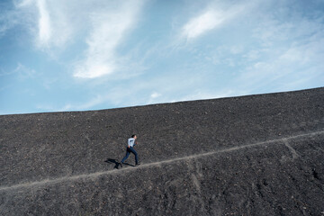Mature businessman running up a disused mine tip