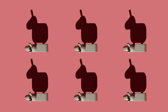 Pattern of small brown donkey figurines against pastel red background
