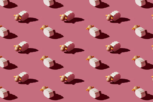Pattern of small white sheep figurines against red background