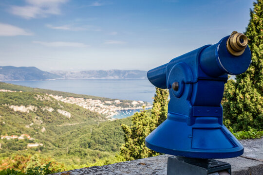 Croatia, Istria, Rabac, Coastline and Adriatic sea with coin operated binoculars in foreground