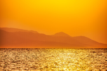 Idyllic shot of Island Rum against clear orange sky during sunset, Lochaber, Scotland, UK