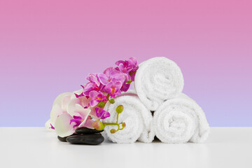 Fototapeta na wymiar Beautiful pink flowers and white towels on pink background