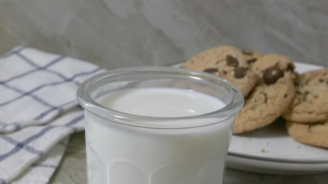 Dunking A Chocolate Chip Cookie Into A Glass Of Milk Close Up