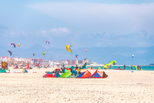 Spain, Andalucia, Tarifa, windsurfers and kite surfers on the beach - Powered by Adobe