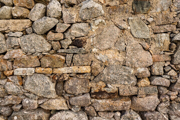 Old stone house wall texture. Warm color. Example of masonry craft and old construction technology