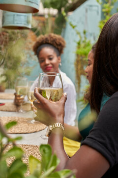 Woman sitting in a restaurant with her friends drinking white wine
