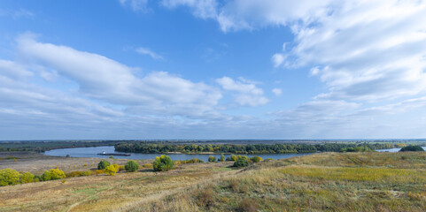 Landscape panorama with a river. Autumn landscape with a view of the river along which the barge sails.