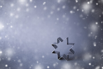 Cookie cutter on snowy background. Copy space.