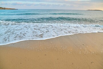 Fototapeta na wymiar Seascape at sunrise, sea background, foam, sand, dawn.
