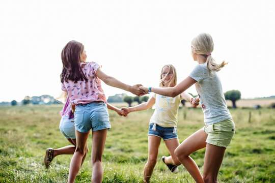Happy girls dancing on a field together