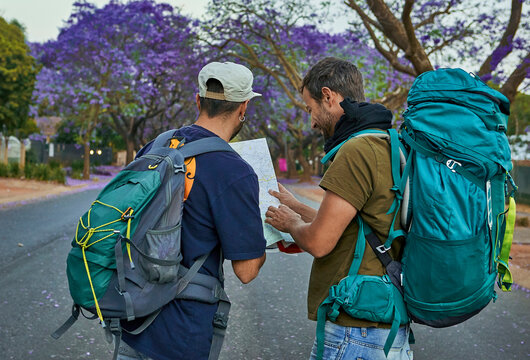 Two backpackers checking a map on a street