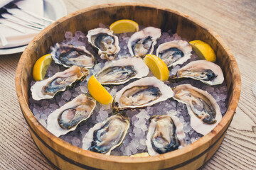 a dozen oysters on ice with lemon