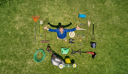 View from above of a gardener in standing on meadow with all the tools he need for take care of garden