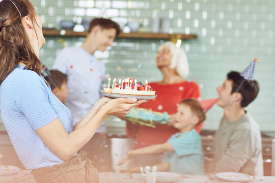 Mother and sons celebrating grandmother's bithday in their kitchen