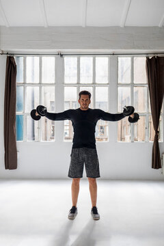 Mature Man Doing Dumbell Training In His Loft