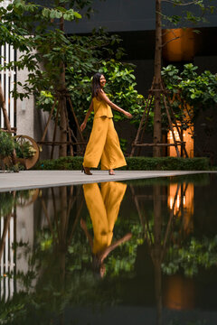 Fashionable woman dressed in yellow dancing in the city
