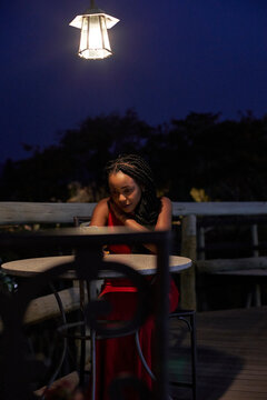 Young woman on a terrace checking her smartphone at night