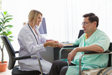 Doctor and patient in the patient room at hospital. Female doctor examining the senior male patient pulse with his hands. Woman doctor visiting and checking male patient. Health care concept