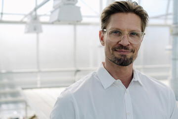 Close-up portrait of confident male professional in greenhouse