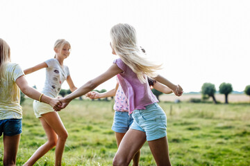 Happy girls dancing on a field together