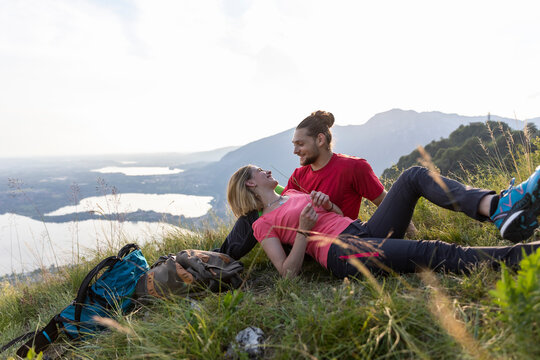 Hiking couple taking a break, lying in mountain meadow