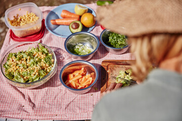 Woman preparing vegetarian food at outdoor table