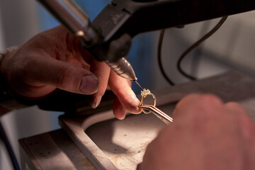 Man working in a welding a diamond ring with a welding machine