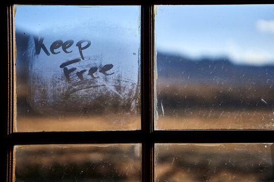 The words keep free written on a steamed windowpane