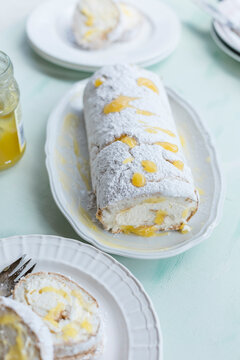 Lemon baiser roll sprinkled with icing sugar on serving plate
